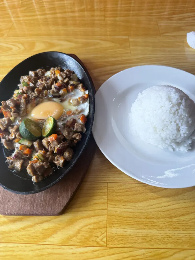 Pork sisig on a hot plate with rice, Bucana